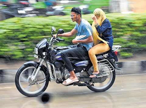Braving downpour, a couple goes on a bike in Tirupati on Saturday | Madhav K