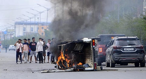Smoke billows from a vehicle allegedly burned by the Meitei community tribals protesting to demand inclusion under the Scheduled Tribe category, in Imphal, May 4, 2023. (Photo | AFP)