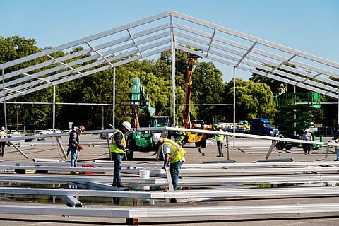 Workers erect a tent in a parking lot in Bronx, New York, as a temporary shelter for thousands of international migrants who have been bused into the Big Apple. (File Photo | AP)