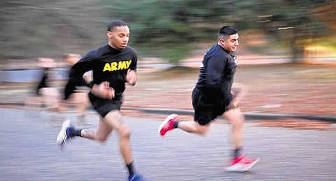 Army Staff Sgt. Daniel Murillo, (R), runs up hill as part of his physical training. (Photo | AP)
