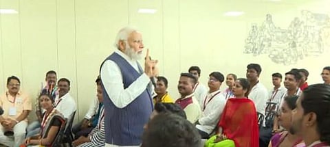 PM Modi interacting with members of the Hakki Pikki tribe evacuated from strife-torn Sudan, in Shivamogga, Karnataka. (Photo | Twitter/@narendramodi)