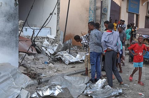 Residents pause to assess the damages at the site of an attack at the Pearl Beach Hotel in Mogadishu. (Photo | AFP)