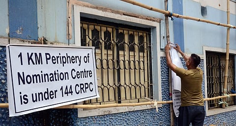 A worker ties banners outside the BDO office Serampore nomination centre as candidates arrive to file nominations for the West Bengal Panchayat polls, in Hooghly on Monday. (Photo | ANI)