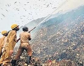 Officials dousing the fire that broke out at Ghazipur landfill in Delhi. (Photo | EPS)