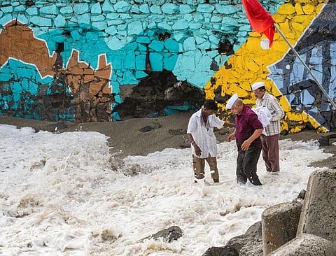 Locals react as high tidal waves lash the shore ahead of the landfall of Cyclone Biparjoy, in Mumbai, on June 14, 2023. (Photo | PTI)