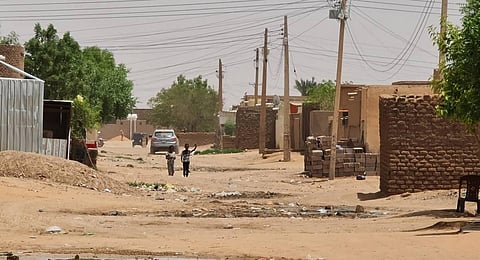 Youths walk on a street as fighting continues in Khartoum. (Photo | AFP)