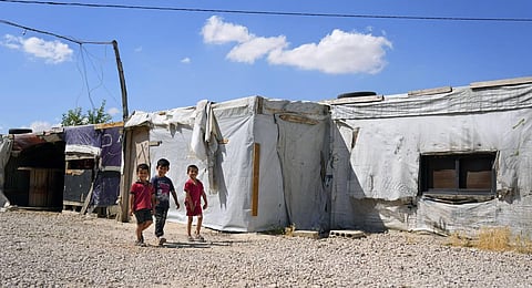 Syrian children walk past their family tents at a refugee camp in the town of Bar Elias, in Lebanon's Bekaa Valley. (Photo | AP)