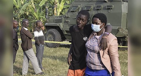 A boy is conforted at the scene of an attack in Mpondwe, Uganda, on June 17, 2023 at the Mpondwe Lhubiriha Secondary School. (Photo | AFP)