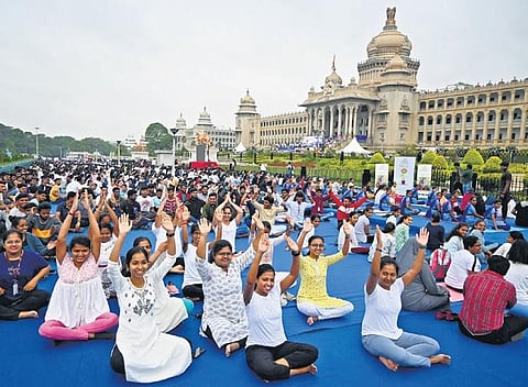 Participants perform yogasanas in front of Vidhana Soudha, on the occasion of International Day of Yoga, in Bengaluru on Wednesday | Express