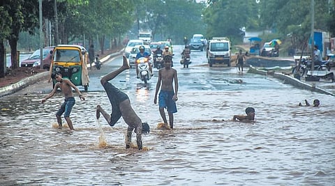 Kids practice somersault on a waterlogged road in Chandrasekharpur as the first monsoon shower lashed the capital city, on Thursday | DEBADATTA MALLICK