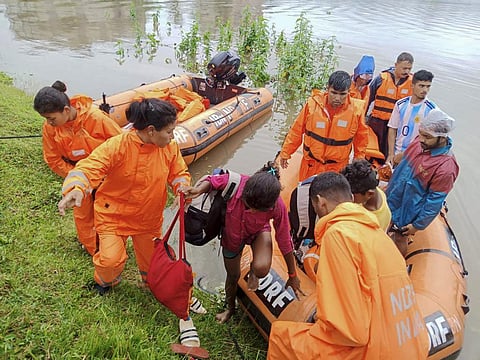 This undated photograph provided by National Disaster Response Force (NDRF) shows NDRF personnel rescuing flood affected people in north eastern Assam state, India. (Photo | AP)