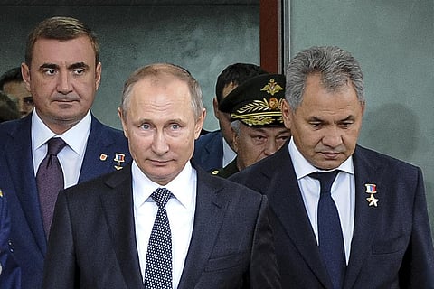 Russian President Vladimir Putin, enter, flanked by Alexei Dyumin, acting governor of the Tula region, left, and Russian Defense Minister Sergei Shoigu, right, visits an exhibition. (Photo | AP)