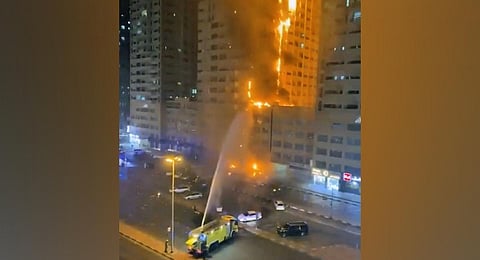 Fire fighters try to extinguish a residential tower which caught fire early morning on Tuesday in Ajman. (Photo | AP)
