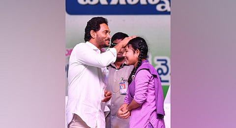 CM Jagan interacting with a student during a programme to disburse Rs 6,392.94 crore under Amma Vodi in Kurupam on Wednesday | Express