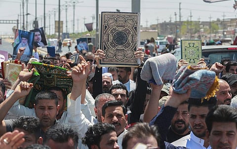 Supporters of the Shiite cleric Muqtada al-Sadr raise the Quran, the Muslim holy book, in response to the burning of a copy of the Quran in Sweden. (Photo | AP)