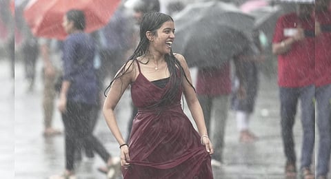 A youngster at Marine Drive amid rain, in Mumbai. (Photo | PTI)