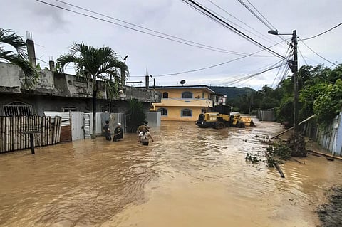 People wade through a flooded street in Esmeraldas, Ecuador. (Photo | AFP)
