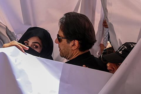 Former Pakistan prime minister Imran Khan (C) with his wife Bushra Bibi (L) arrive to appear at a high court in Lahore on May 15, 2023. (Photo | AFP)