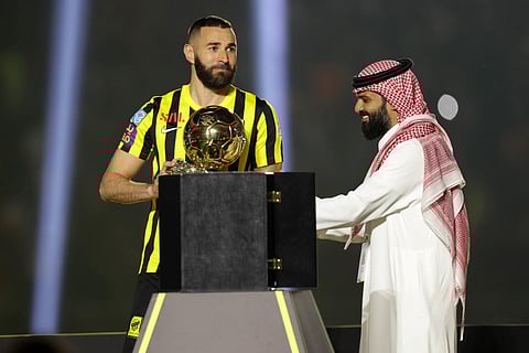 Former Real Madrid striker Karim Benzema hoists the Ballon d'Or, the trophy he won last year, in Jeddah's King Abdullah Sports City stadium as part of his grand unveiling, June 8, 2023. (Photo | AFP)