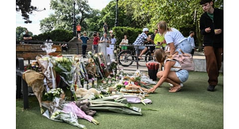 People lay flowers and candles for the victims of the stabbing attack. (Photo | AFP)