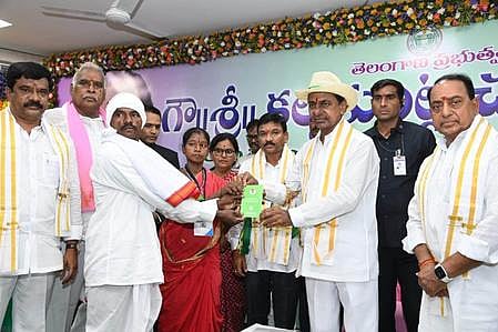 Chief Minister Chandrasekhar Rao hands over patta to a podu farmer in Asifabad on Friday. 