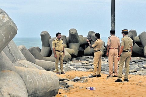 Police officials taking a photograph of their senior officer who is in charge of the rescue mission of the missing fisherman at Muthalapozhi.  ( Photo | B P Deepu)
