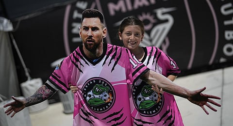 A fan carries a cutout of Messi as a group of South Florida fans waits outside DRV Pink Stadium, home of Inter Miami MLS soccer club, in hopes of catching a glimpse of Messi.