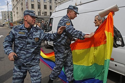 Russian police officers detain a gay rights activist with his flag during an attempt to hold a gay pride parade in Moscow, Russia, on May 27, 2012. (Photo | AP)