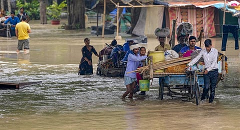 Residents move to a safer place from a flood-affected area following monsoon rains in New Delhi.(Photo | PTI)