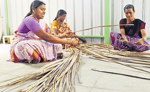 Women sorting coconut leaves for the straw.