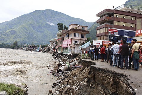 People stand by a road washed away by the River Beas swollen due to heavy rains in Kullu District, Himachal Pradesh, India, Tuesday, July 11, 2023. (Photo | AP)