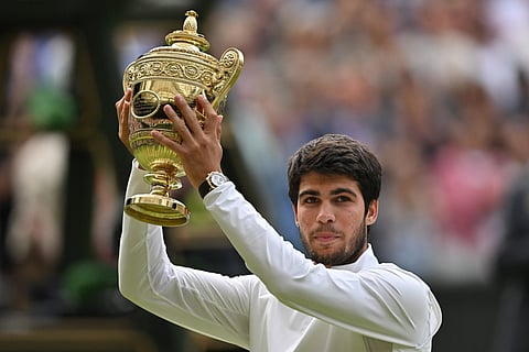 Carlos Alcaraz raises his trophy after beating Novak Djokovic during their men's singles final tennis match of the 2023 Wimbledon Championships in Wimbledon, July 16, 2023. (Photo | AFP)