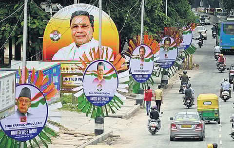 Hoardings with pictures of opposition leaders being put up in Bengaluru on the eve of the two-day opposition conclave, on Sunday. Leaders of 24 political parties will be present   | Shashidhar Byrappa