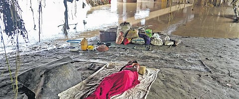 A woman takes shelter under the Old Yamuna Bridge