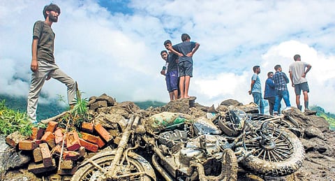Locals stand on the debris following a cloud-burst at Kais in Kullu on Monday (Photo|PTI)