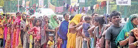 Flood victims stand in a queue to get food items at a relief camp in Mayur Vihar on Wednesday | Parveen negi