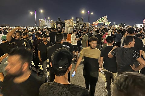 Protesters gather in Baghdad's Tahrir Square, carrying Iraqi flags and images of influential Iraqi Shiite cleric and political leader Muqtada al-Sadr. (Photo | AP)