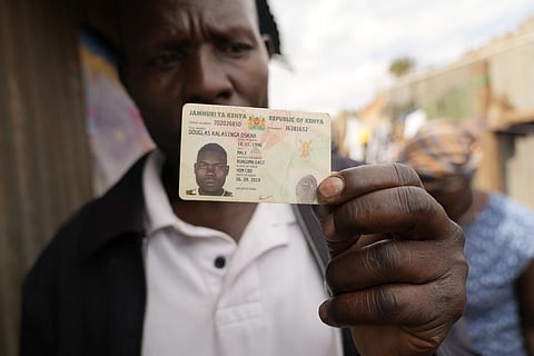Rasta Sakulo, the uncle of Douglas Kalasinga, holds his identification card in Nairobi. ( Photo | AP)