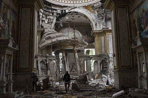 People clean up debris and rubble inside the Odesa Transfiguration Cathedral after it was heavily damaged by Russian missile attacks in Odesa. (Photo | AP)