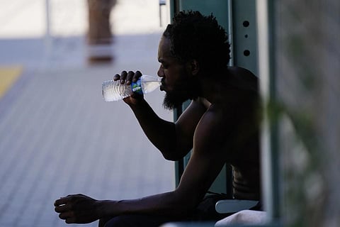 A person drinks a bottle of water in the shade as temperatures are expected to hit 119-degrees (48.3 Celsius), July 20, 2023. (Photo | AP)