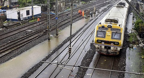 A train runs on a waterlogged railway track between Marine Lines and Churchgate after monsoon rainfall, in Mumbai. (Photo | PTI)