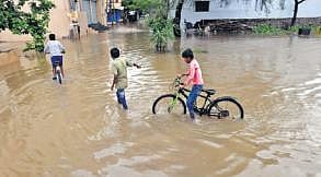 Children wade through the flooded streets of Shivapuri Colony in the city on Thursday | VINAY MADAPU