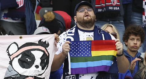 A United States fan holds a flag that combines the Pride flag and the United States flag during the Women's World Cup Group E soccer match between the United States and Vietnam. (Photo | AP)