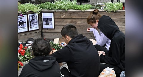 Friends and colleagues of killed staff members gather to mourn in front of a makeshift memorial next to the remains of a restaurant destroyed in a recent missile strike. (Photo | AFP)