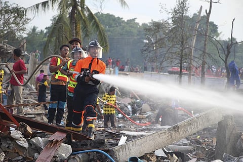 A fireman sprays water after an explosion occured at a firework warehouse in Narathiwat province southern Thailand on Saturday, July 29, 2023. (Photo | AP)
