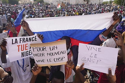 Nigeriens holding a Russian flag and placards participate in a march called by supporters of coup leader Gen. Abdourahmane Tchiani in Niamey. (Photo | AP)