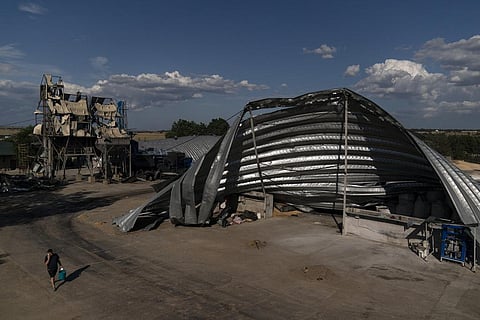 An employee walks near mangled warehouses at a grain facility in Pavlivka, Ukraine, Saturday, July 22, 2023, following Russian missile attacks. (Photo | AP)