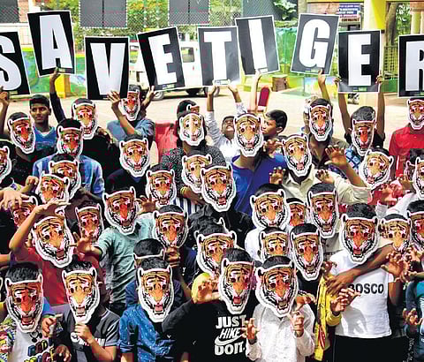 Underprivileged children from Bosco Mane wear tiger face masks to celebrate International Tiger Day at Chamarajpet in Bengaluru,  on Saturday | Shashidhar Byrappa