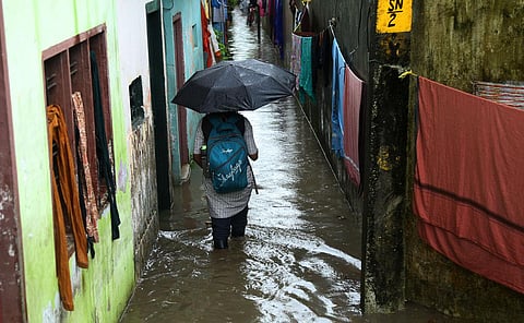 Children and their parents wading through a waterlogged street at P&T Colony in  Kochi following the heavy rain. (Photo | T P Sooraj, EPS)