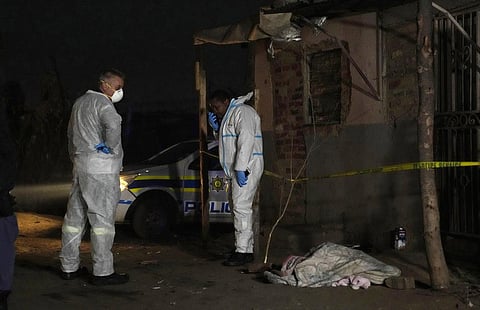 Police stand near a covered body in the Angelo settlement in Boksburg, South Africa. (Photo | AP)